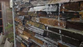 waterval watermuur met maaskeien rvs goot met ribbelslang zwart en aose pomp natulis 5500 liter tuinontwerp tilburg wijk de blaak vught oisterwijk berkel enschot