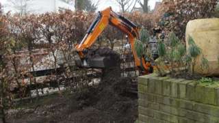 afvoeren zwarte grond met kruiwagen doormiddel van container het oude grond wad later gekeurd en gezeeft voor hergebruik