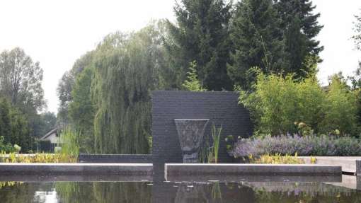 heldere vijver, vissen die je ziet zwemmen, kikkers op de stenen muurtjes tuin in de Blaak in Tilburg, hovenier Udenhout Brabant