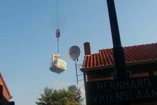 pakketten natuursteen over het huis draaien met telekraan zodat alles op de werkplek staat flagstone leggen 