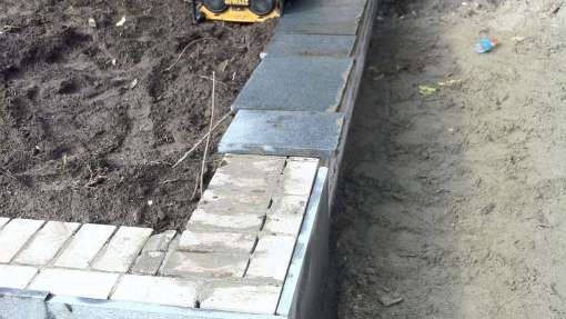 stellen tuinmuur voor hoogte en diepte in de tuin de tuinmuur wordt strak afgewerkt en bekleed met natuursteen, voorlijmen muur met voorlijm en dan beplakken met tegels Tilburg Eindhoven Breda Udenhout Den Bosch Reeshof Maaspoort, Utrecht